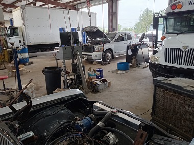 The automotive and diesel service garage at Pete's Tire and Automotive Service filled with vehicles getting worked on in Waxahachie, TX