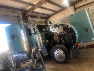 Blue heavy-duty tractor truck wit hood popped at Pete's Tire & Automotive Service for HD truck repair